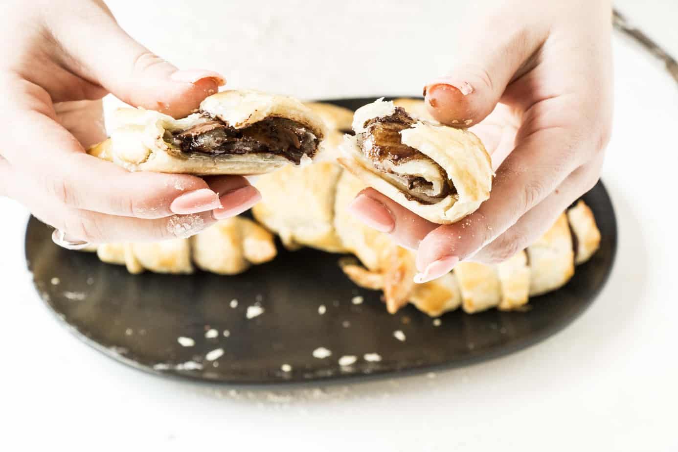 Easy Nutella Croissants broken in half with chocolate oozing out.