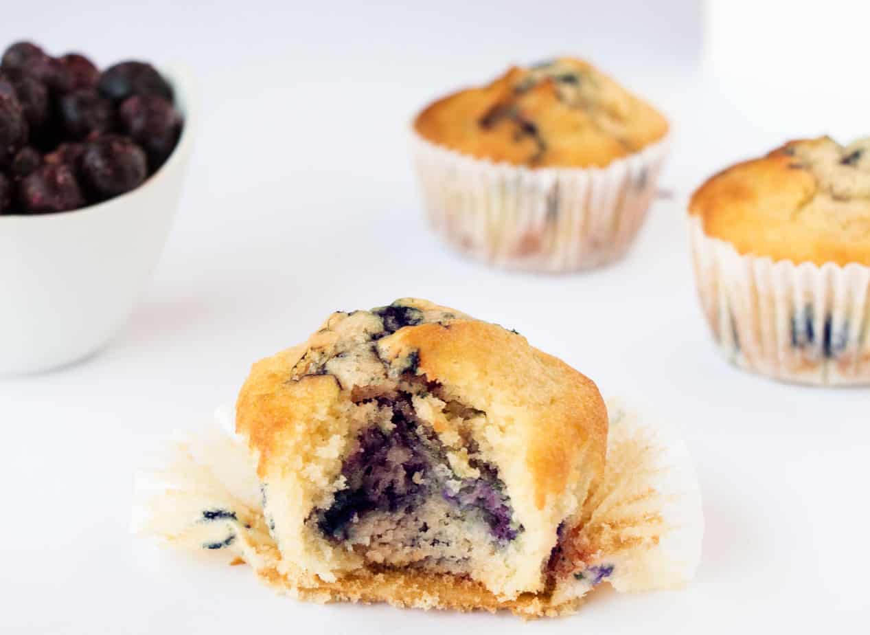 A blueberry muffin with a bite taken out.