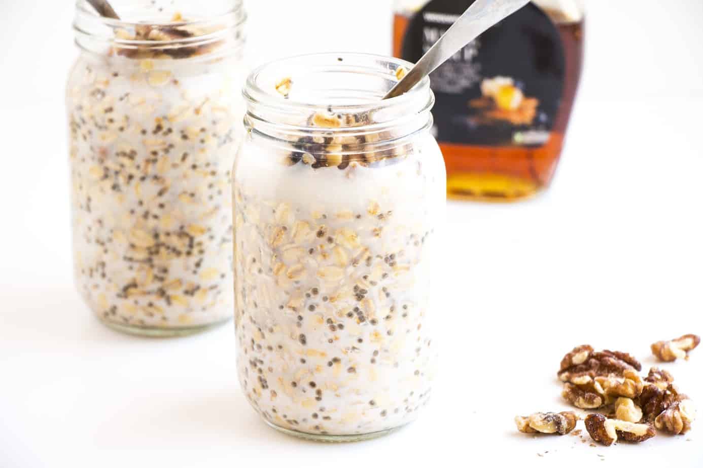 Overnight Oats in glass jars with spoons and nuts.