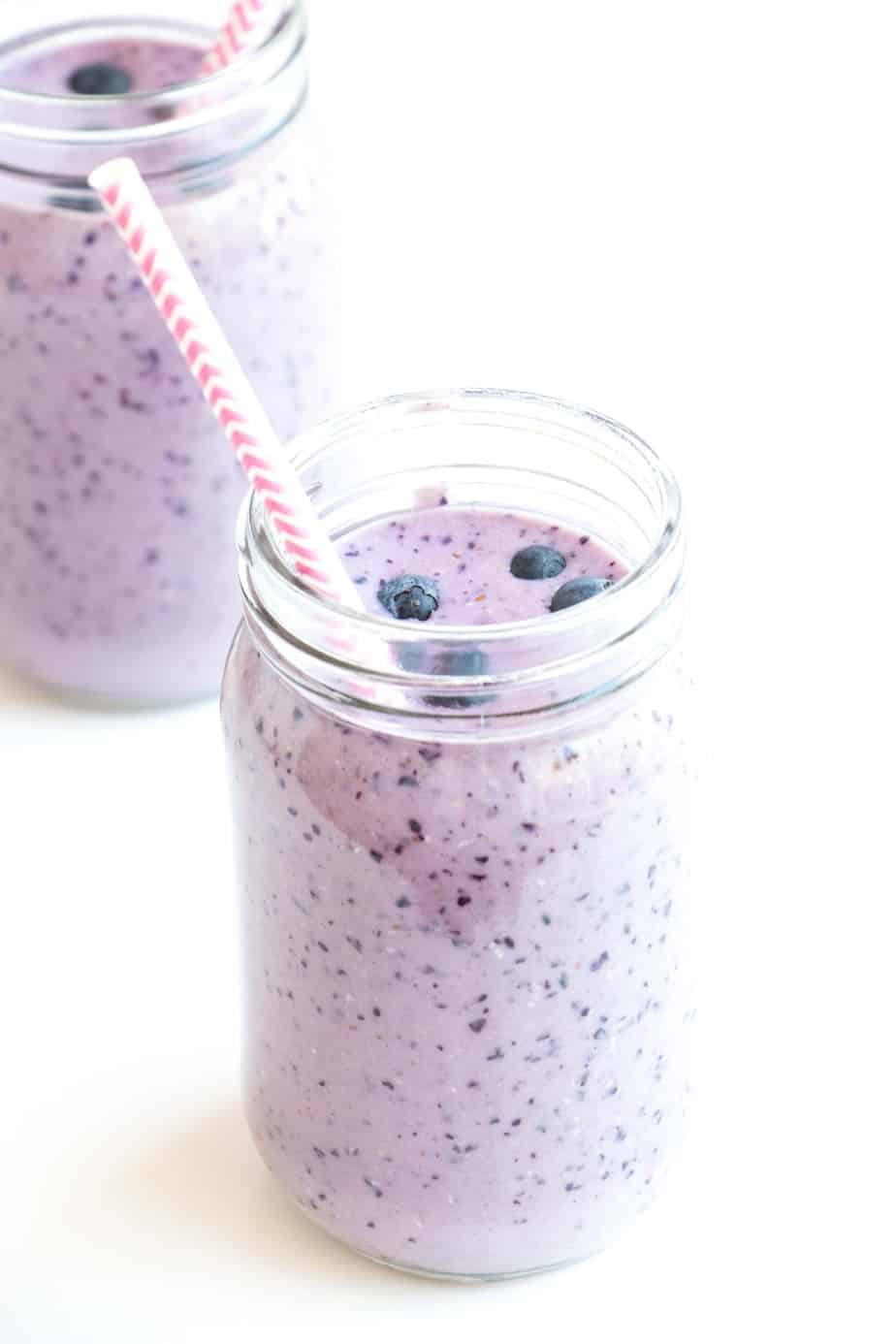 Healthy Blueberry Smoothie with fresh blueberries and a straw.