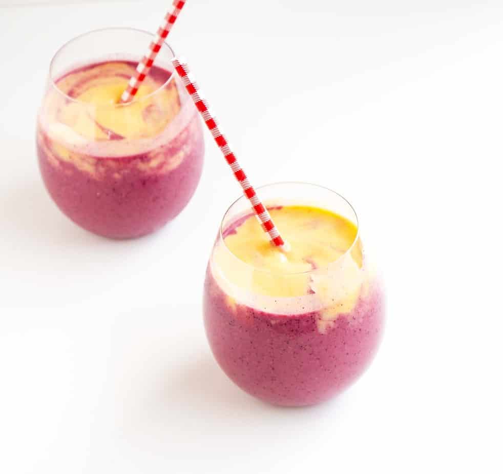 Two smoothies in glasses with straws