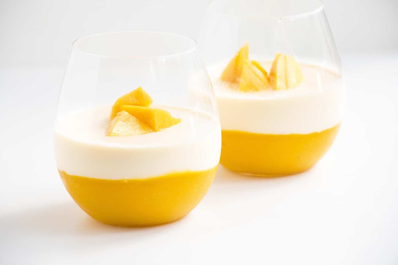 Two panna cotta desserts in serving glasses.