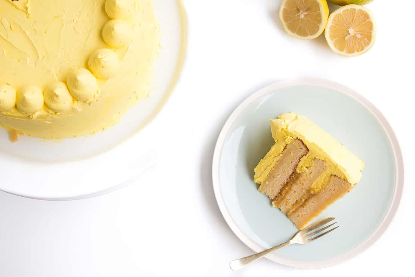 A slice of layered cake with yellow frosting.