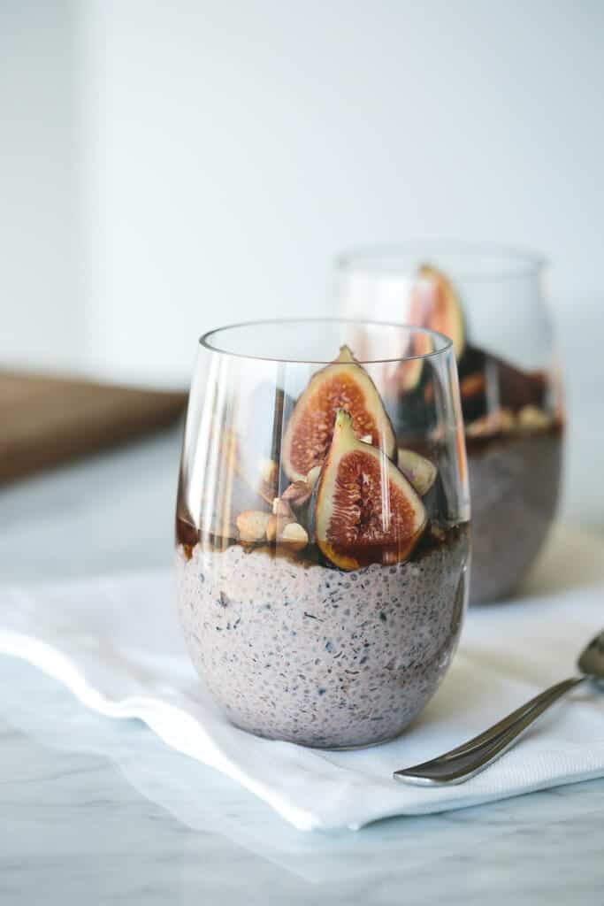 Figs, nuts, and chia seed in a glass with silver spoon.