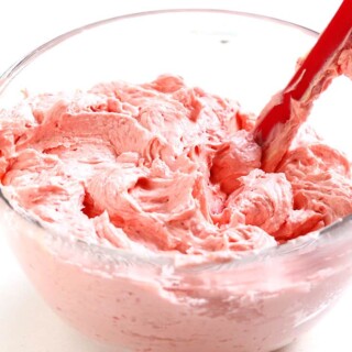 A glass bowl filled with raspberry buttercream frosting.