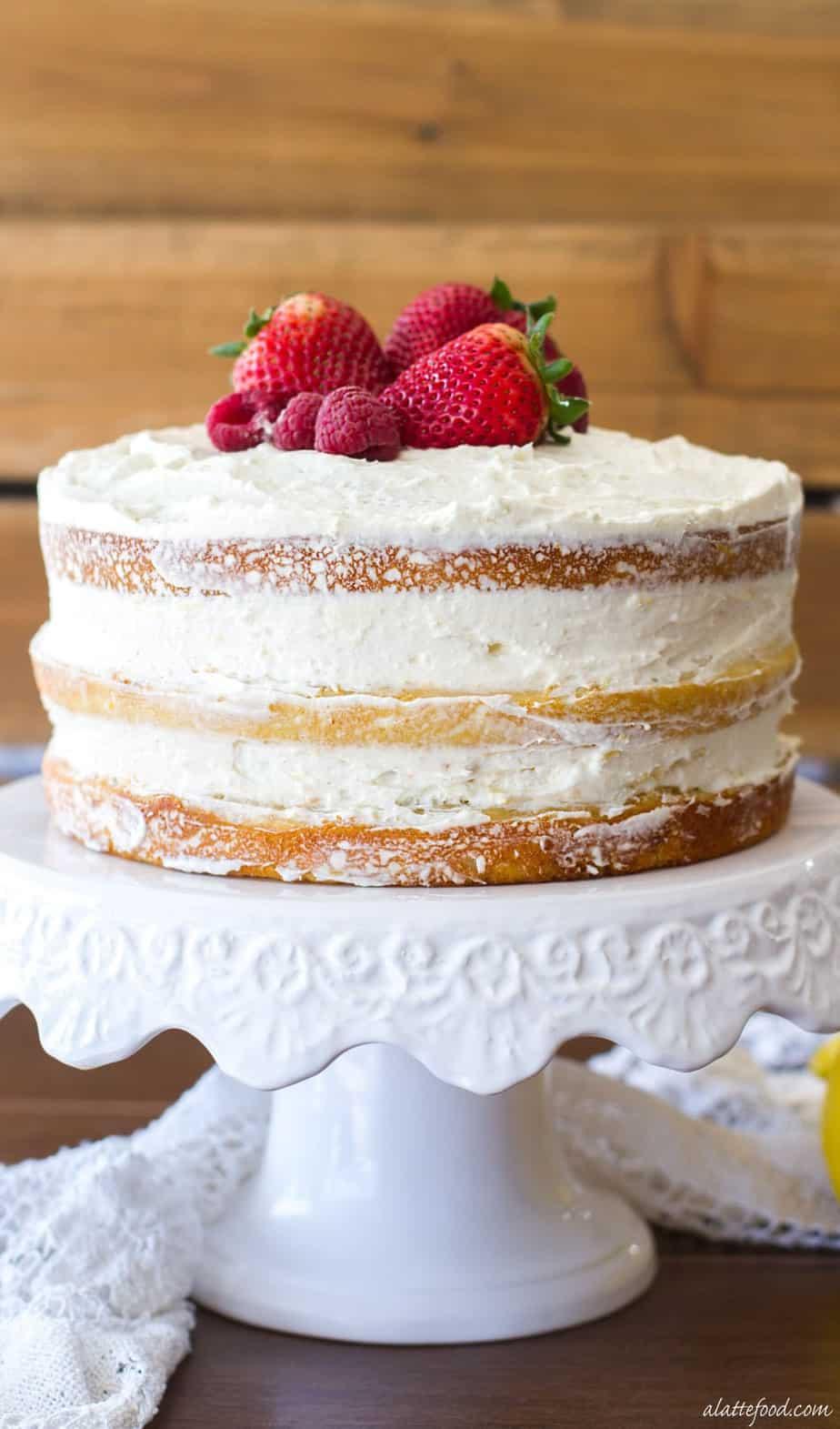 A layered vanilla cake topped with fresh berries.