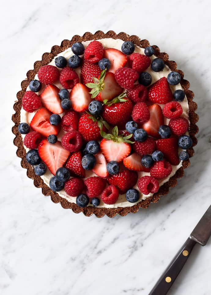 A berry tart topped with fresh berries.