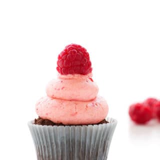 A chocolate cupcake topped with raspberry buttercream frosting.