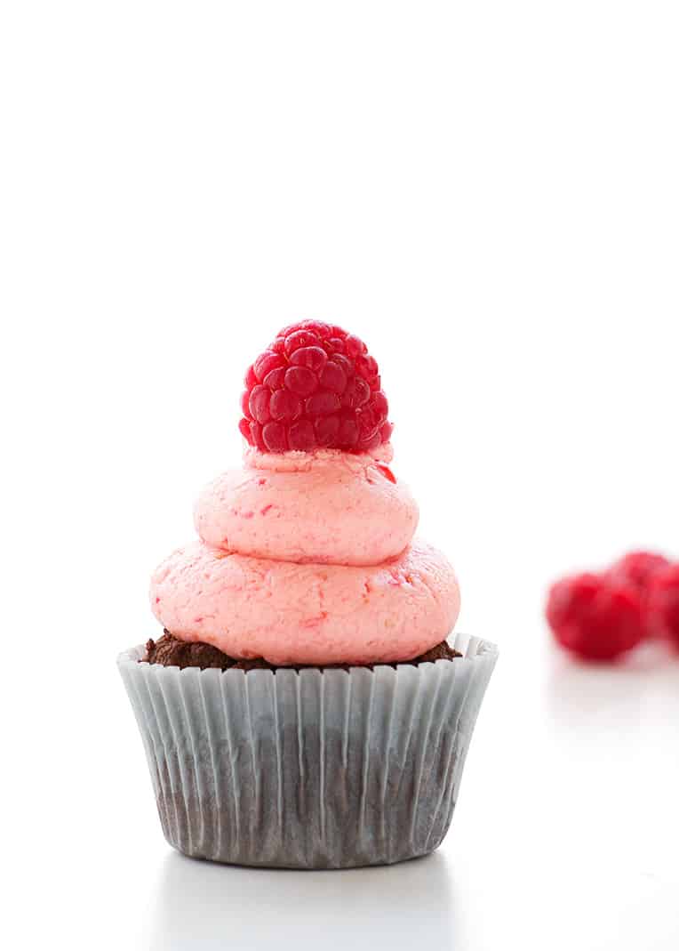 A chocolate cupcake topped with raspberry buttercream frosting.