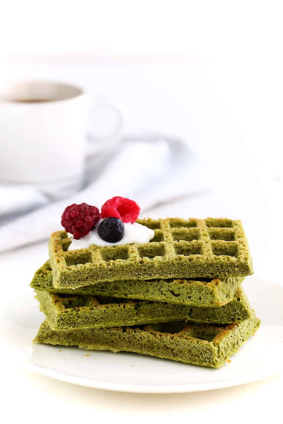 A stack of green tea waffles with fresh berries.