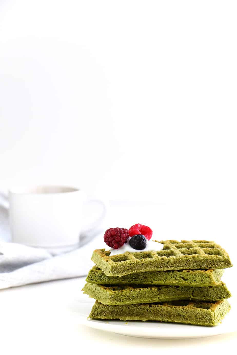 A stack of green tea waffles with berries.