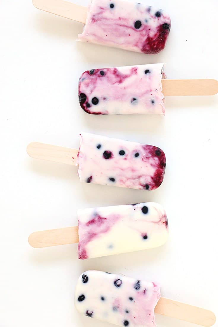 Berry popsicles on white background.