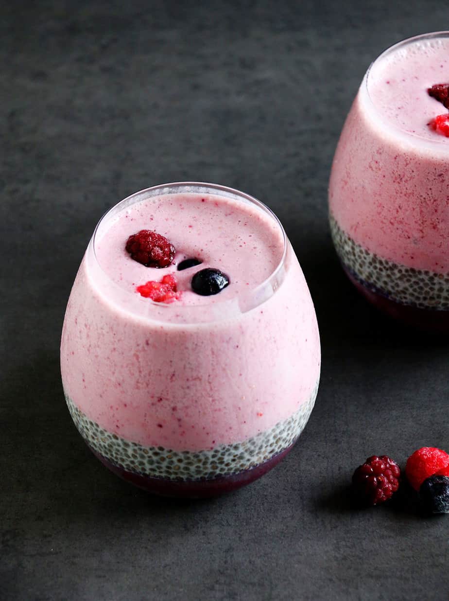 A healthy Layered Berry Smoothie Chia Pudding on a black background.