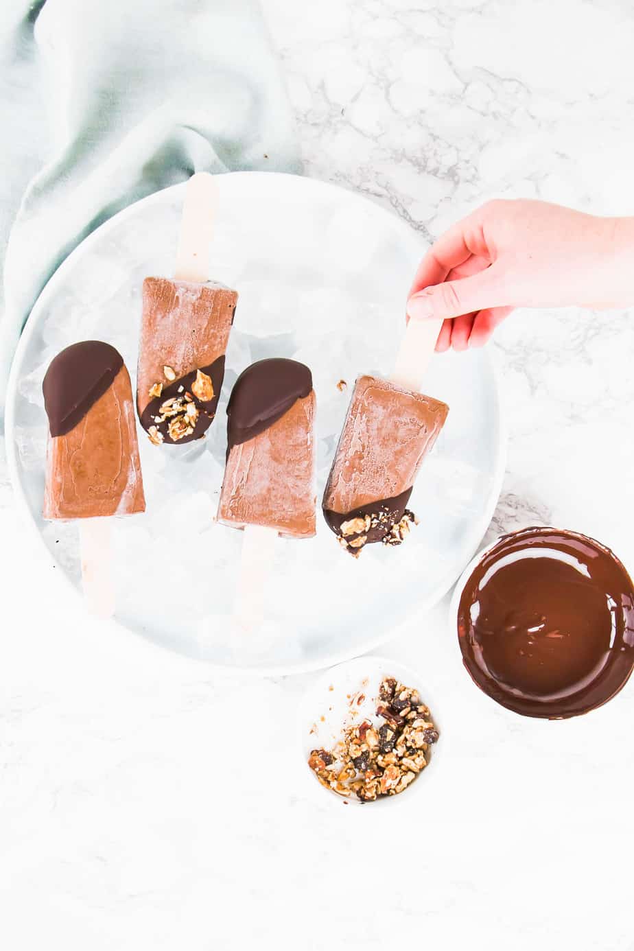 These Vegan Chocolate Protein Popsicles make the best on the go breakfast or the ultimate summer dessert. Made with vegan protein, coconut milk and topped off with dark chocolate ganache and crunchy granola.