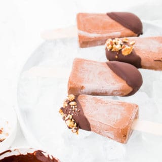 These Vegan Chocolate Protein Popsicles make the best on the go breakfast or the ultimate summer dessert. Made with vegan protein, coconut milk and topped off with dark chocolate ganache and crunchy granola.