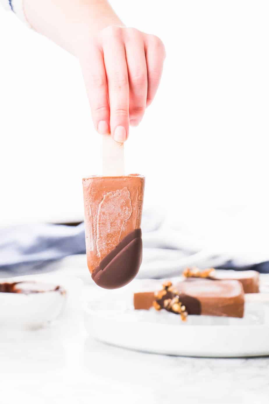 These Vegan Chocolate Protein Popsicles make the best on the go breakfast or the ultimate summer dessert. Made with vegan protein, coconut milk and topped off with dark chocolate ganache and crunchy granola.