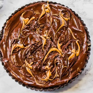 This Vegan Peanut Butter Chocolate Tart is the ultimate no-bake decadence. No one will even know it's vegan! Made with oreos, peanut butter and a little coconut oil and cream!