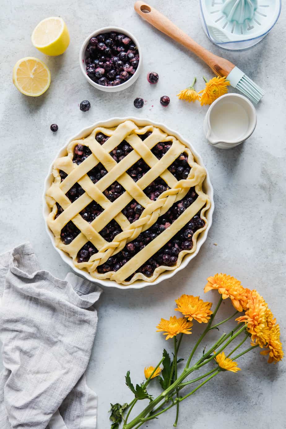 An unbaked blueberry and strawberry pie with fresh flowers and berries.