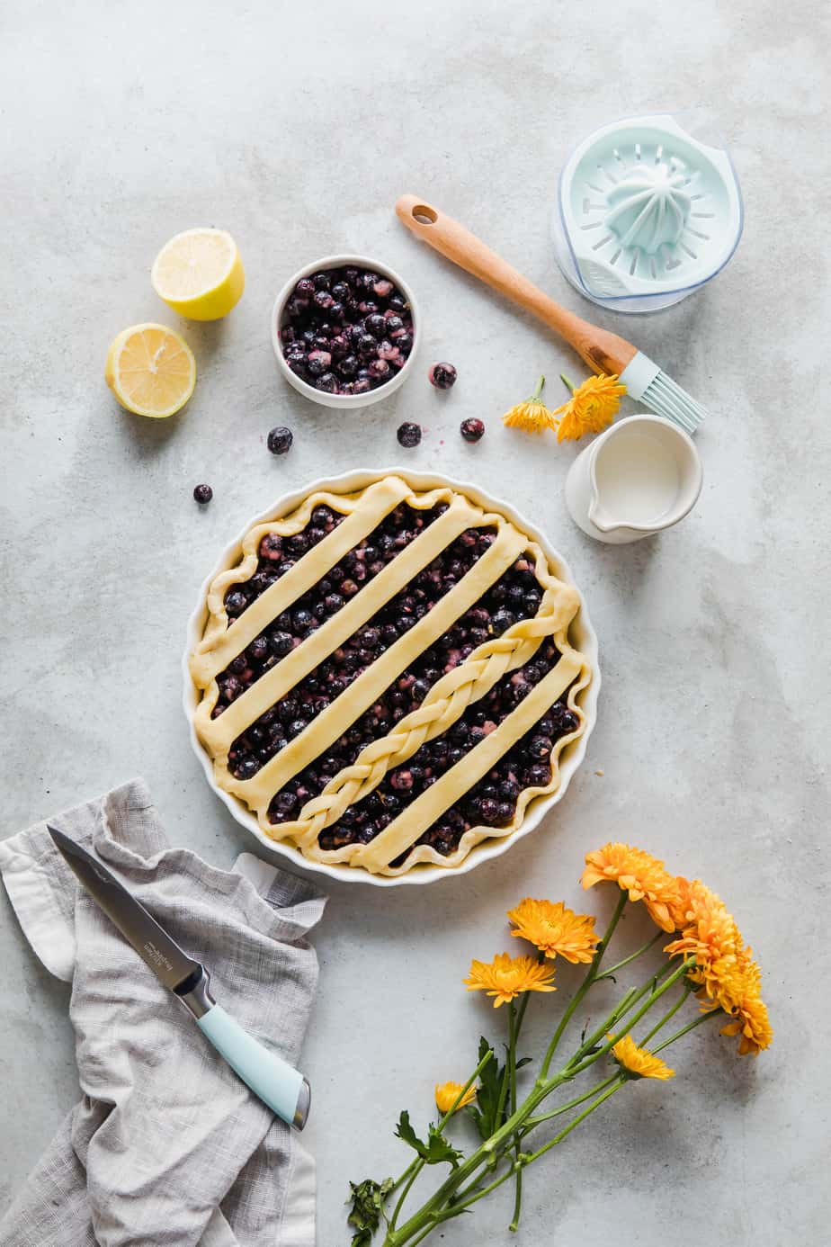 An unbaked pie with a lattice pie crust in a white dish.