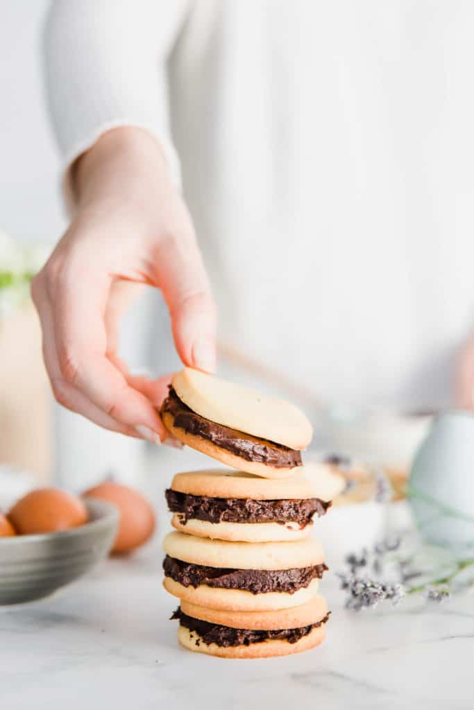 These Super Easy Chocolate Ganache Cookie Sandwiches are not only completely delicious but also so fun and simple to make! Who wouldn't want to get their hands covered in sweet cookie dough and creamy ganache!?