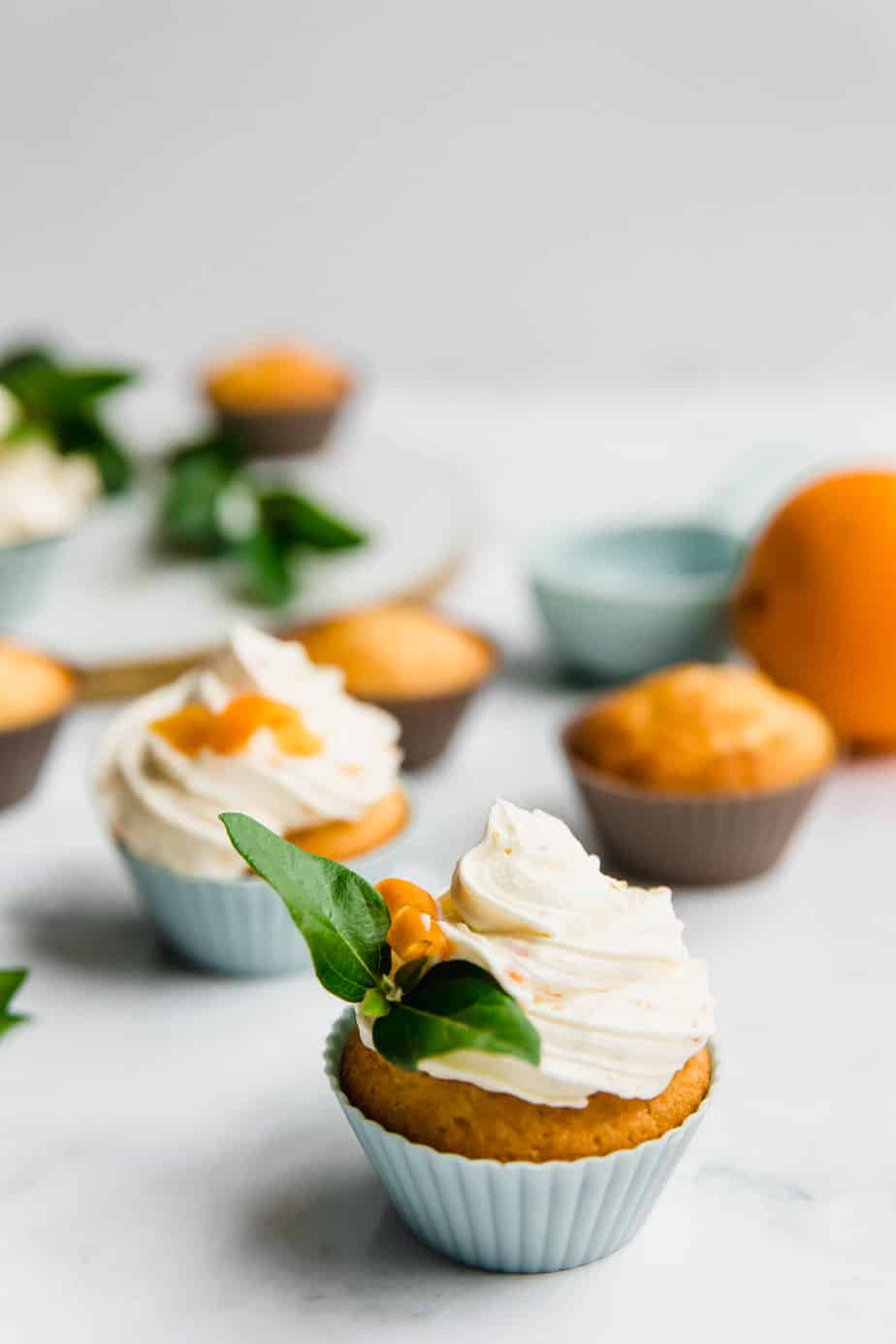 A cupcake with piped frosting and orange zest.