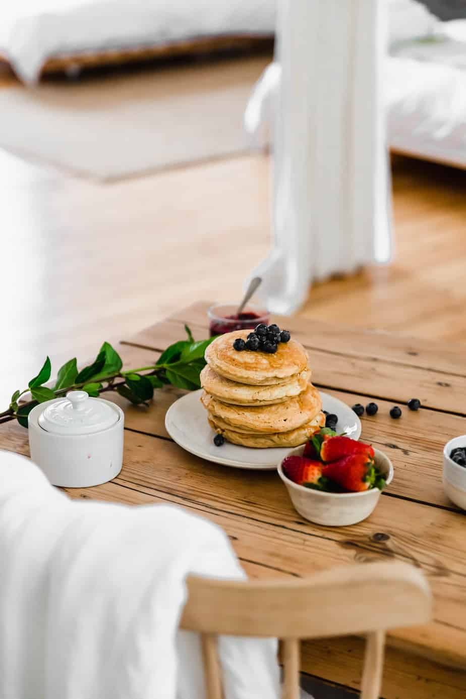 Pancakes on a wooden table with fresh berries.