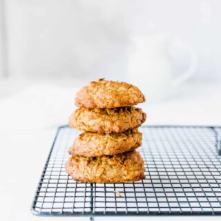 Four carrot oatmeal cookies stacked on a cooling rack.