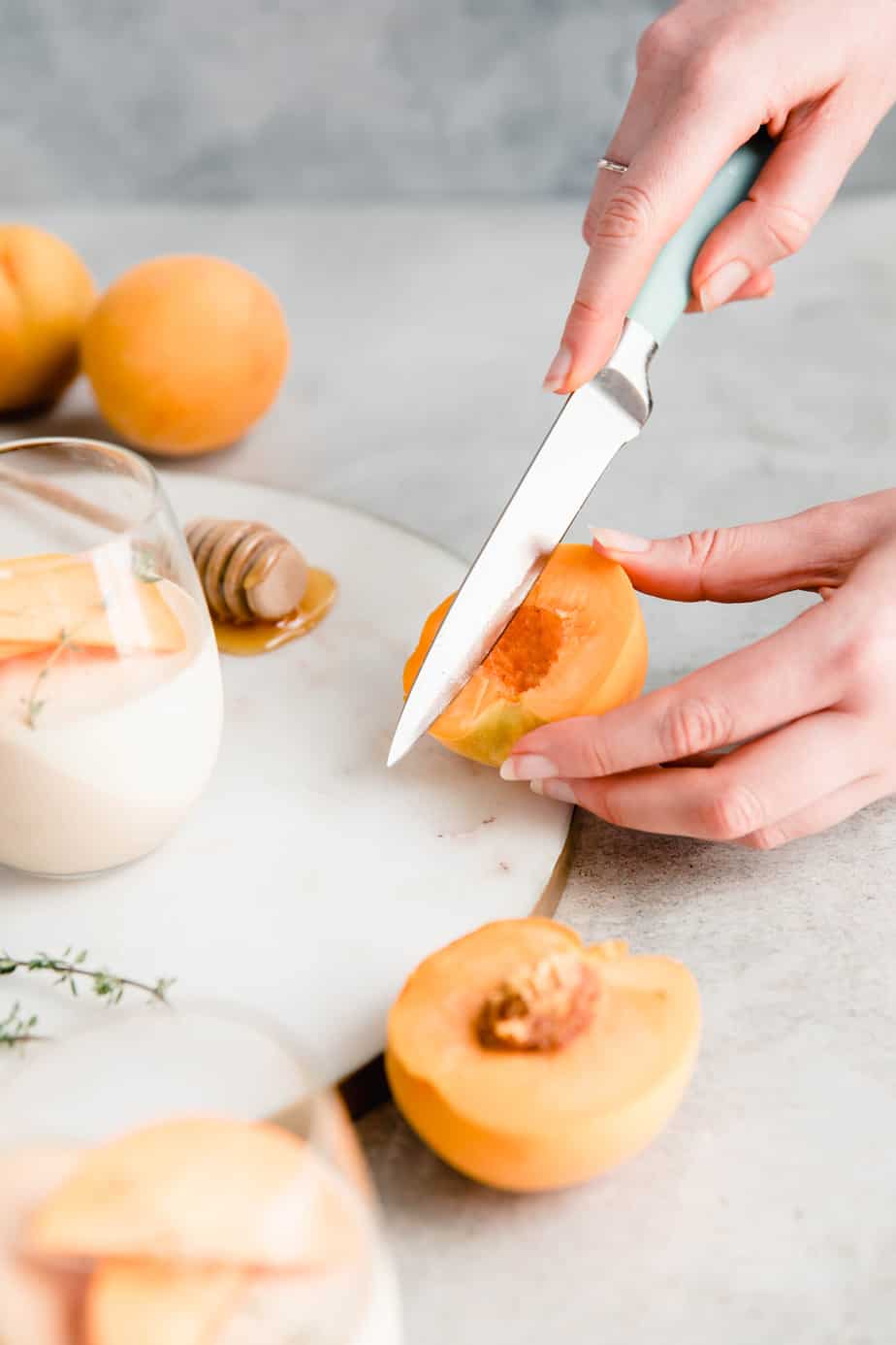 A person cutting a peach