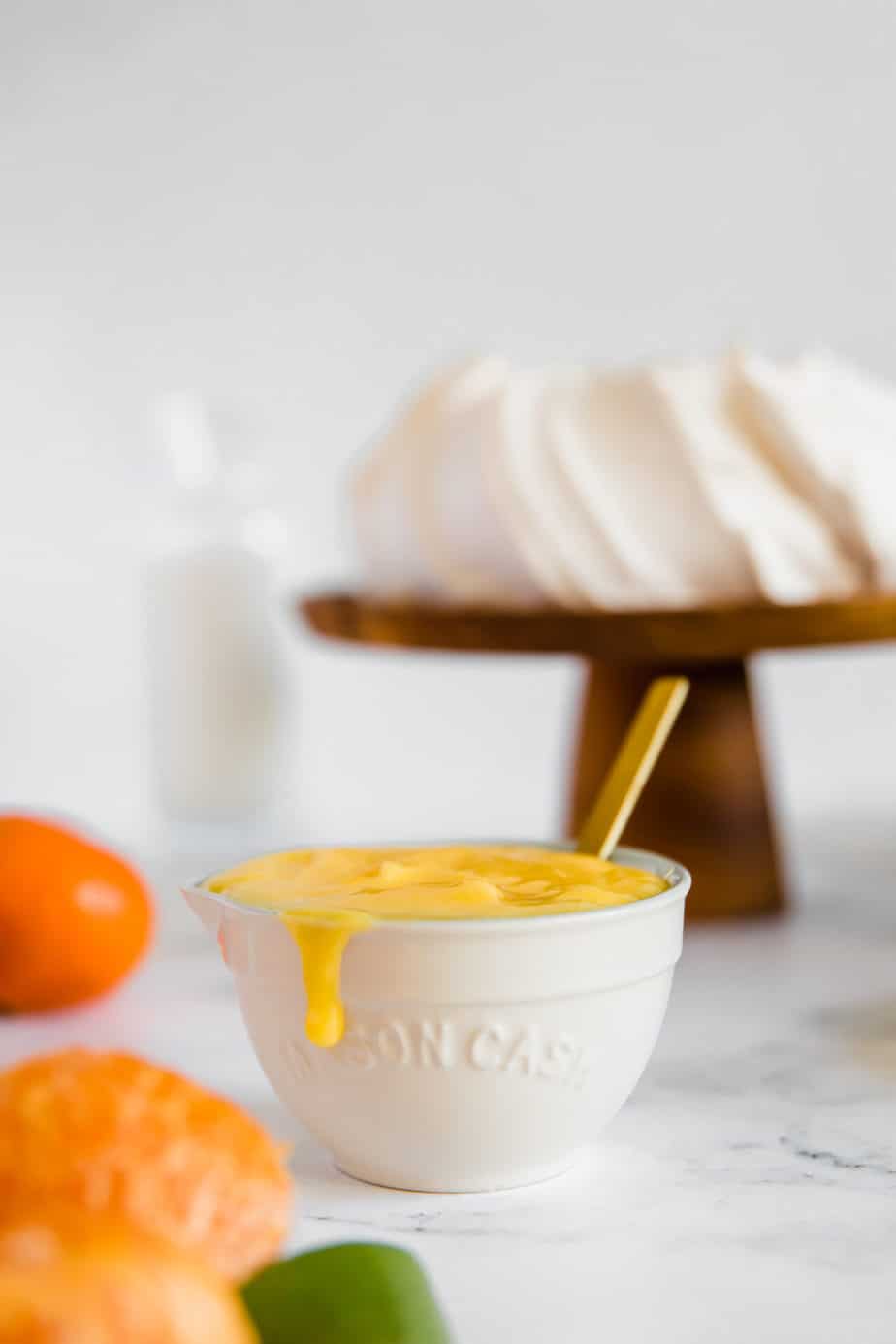 A bowl of clementine curd with a gold spoon.