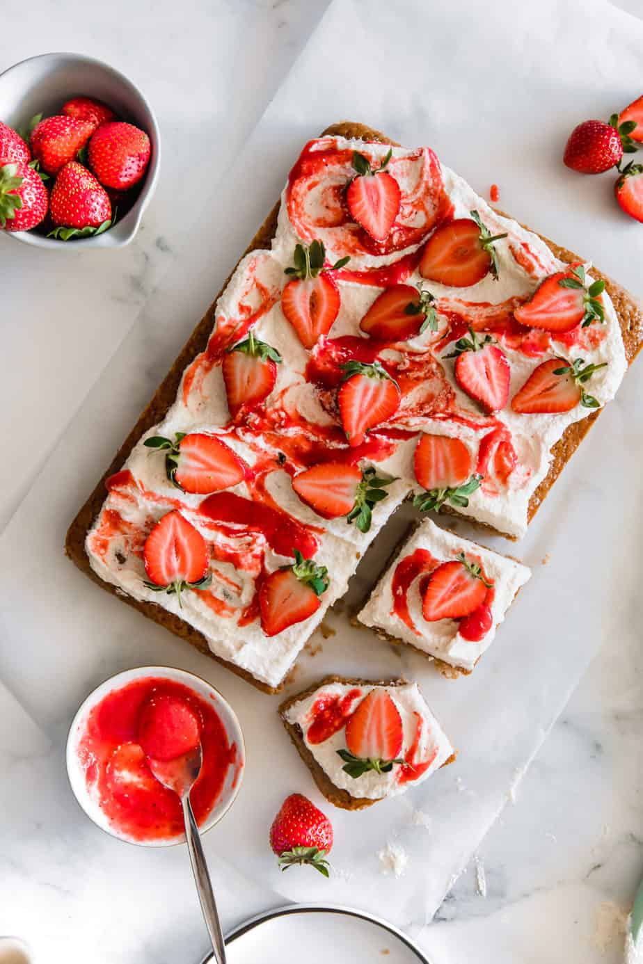 A strawberry lemon sheet cake with strawberry puree and fresh strawberries.