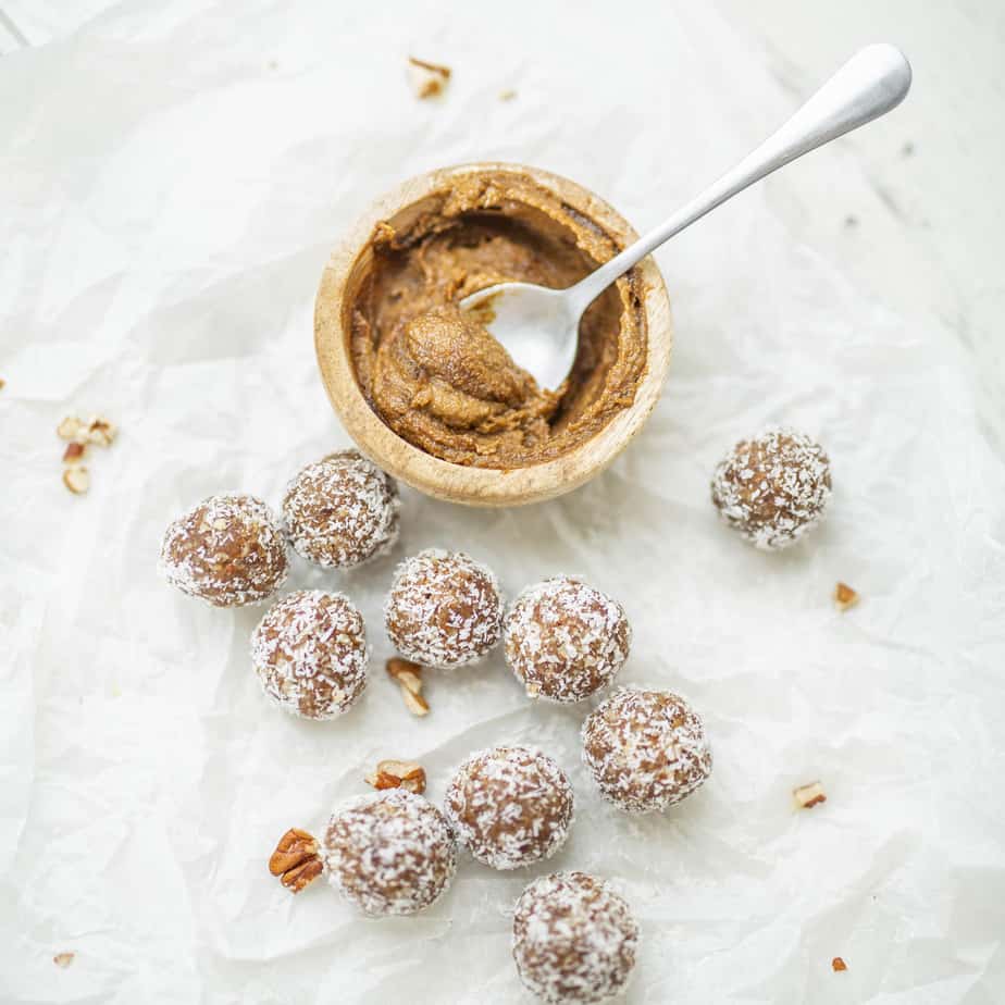 Chopped nuts and bliss balls on a sheet of baking paper.