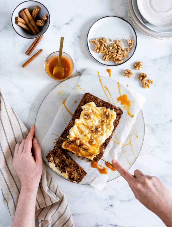 This easy Gluten-Free Apple Cinnamon Loaf Cake is deliciously moist and full of chunks of fresh apples and cozy cinnamon flavour. Pile on the dreamy cream cheese frosting and a drizzle of caramel and it is the perfect companion to a warm cup of tea or coffee.