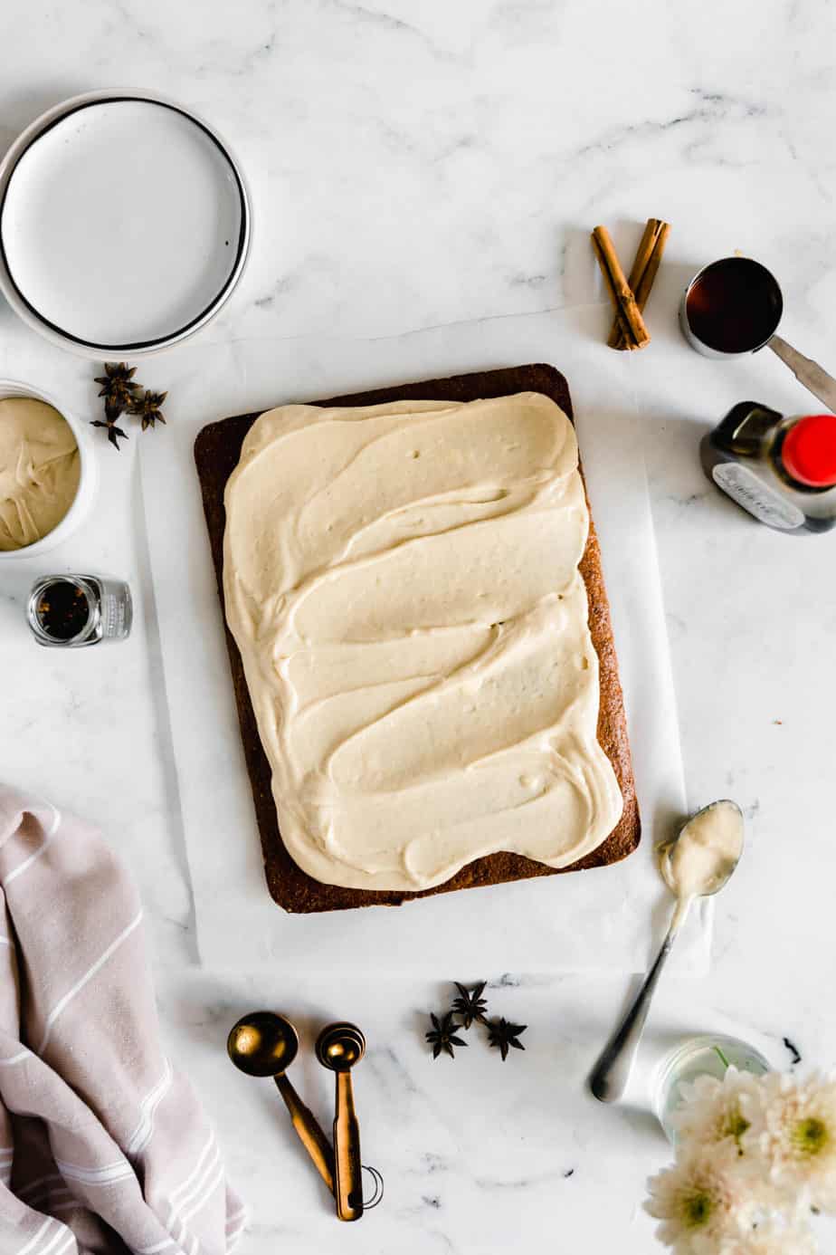 A baked pumpkin sheet cake with a thick layer of vegan cream cheese frosting.