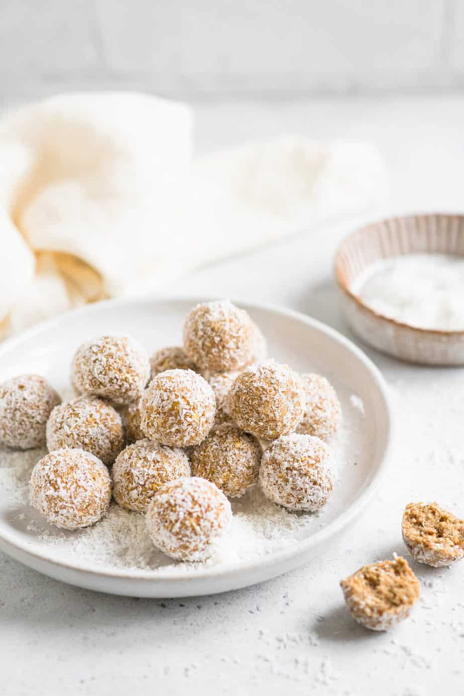 A cream plate filled with small brown energy bites.