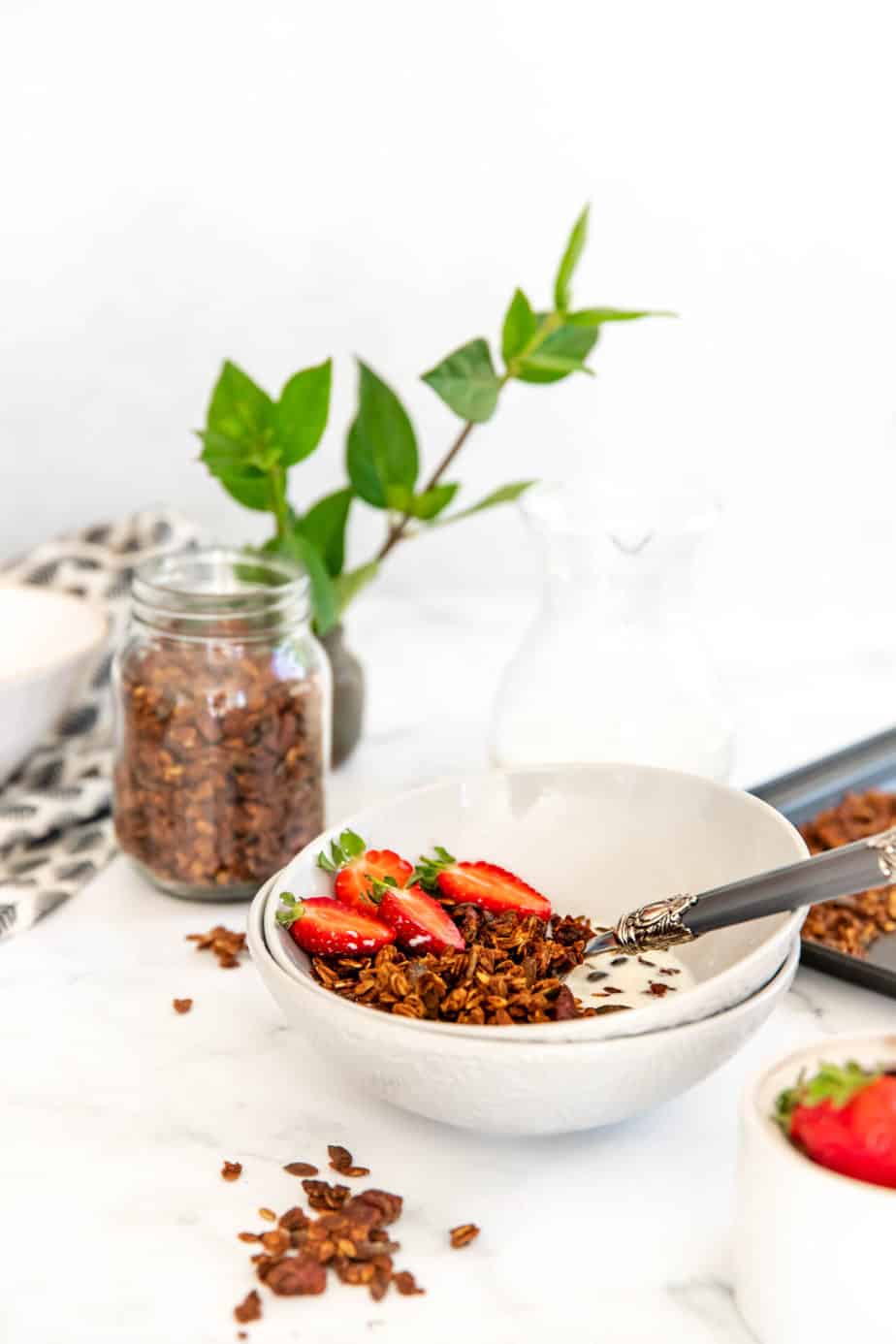 A bowl of banana bread granola sitting on a white table.