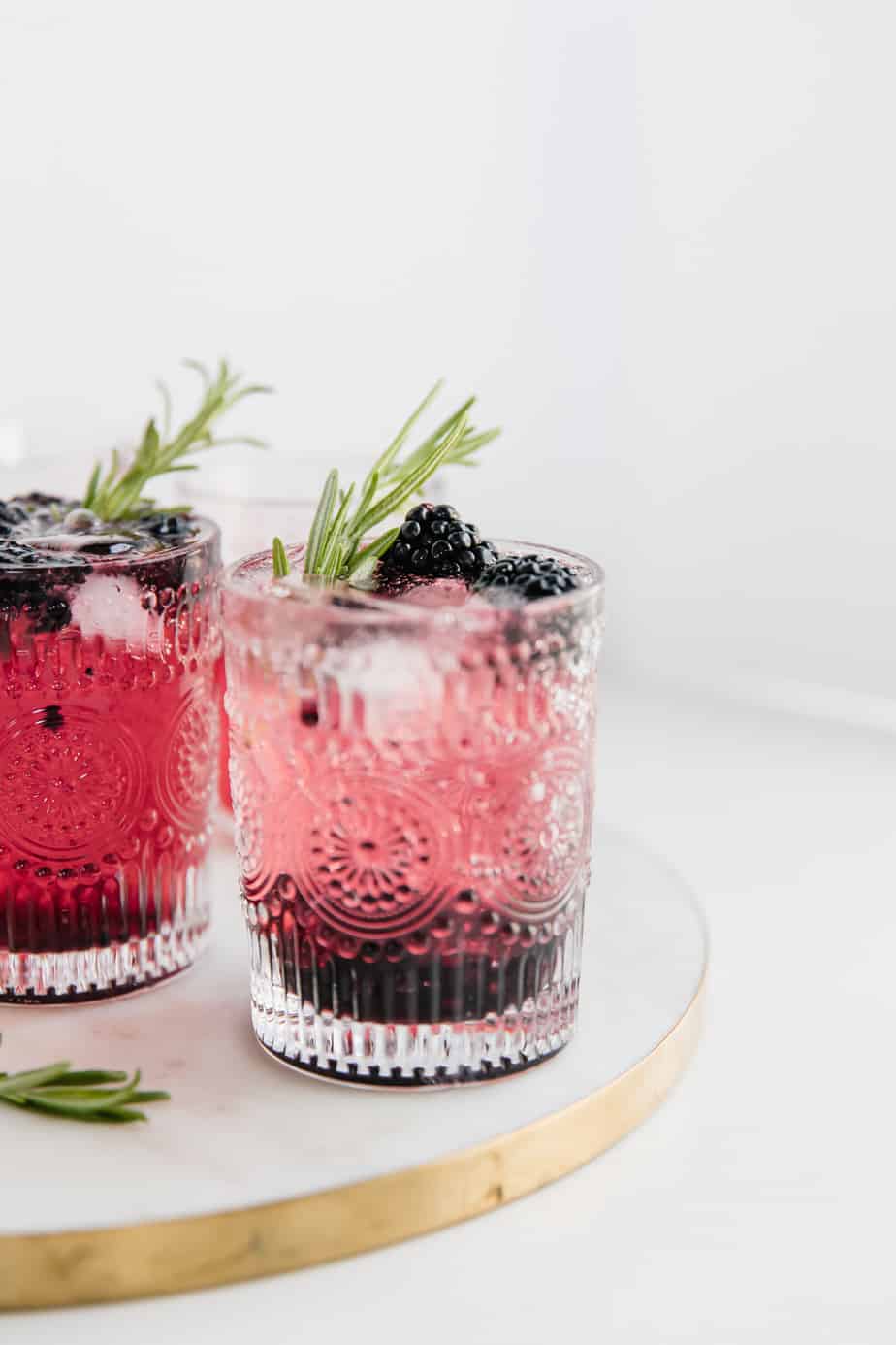 A blackberry gin and tonic with fresh berries and rosemary.