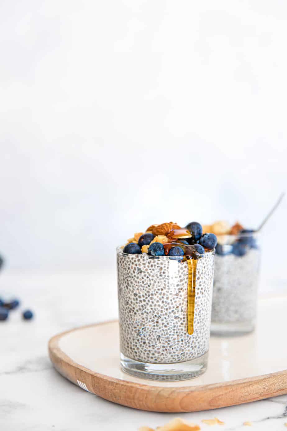 Blueberry Coconut Chia Puddings in glasses with fresh berries