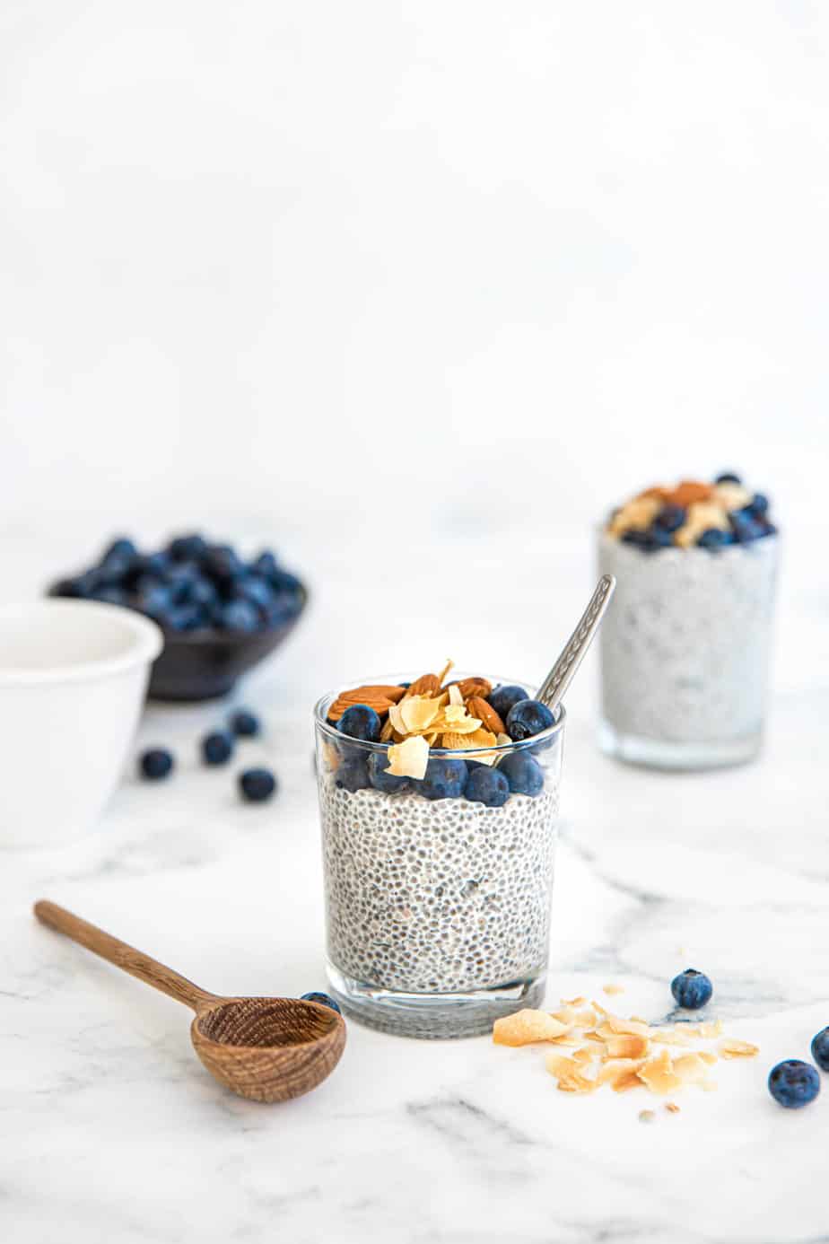 Blueberry Coconut Chia Puddings in glasses with fresh berries