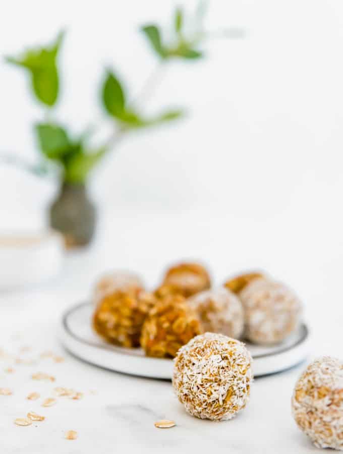 carrot cake energy balls rolled in coconut on small plate