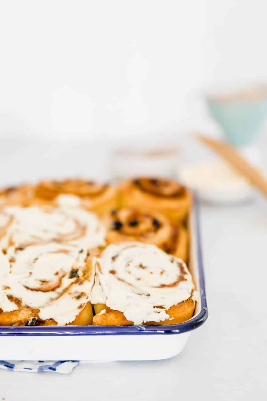 A tray of cinnamon rolls with frosting on top.