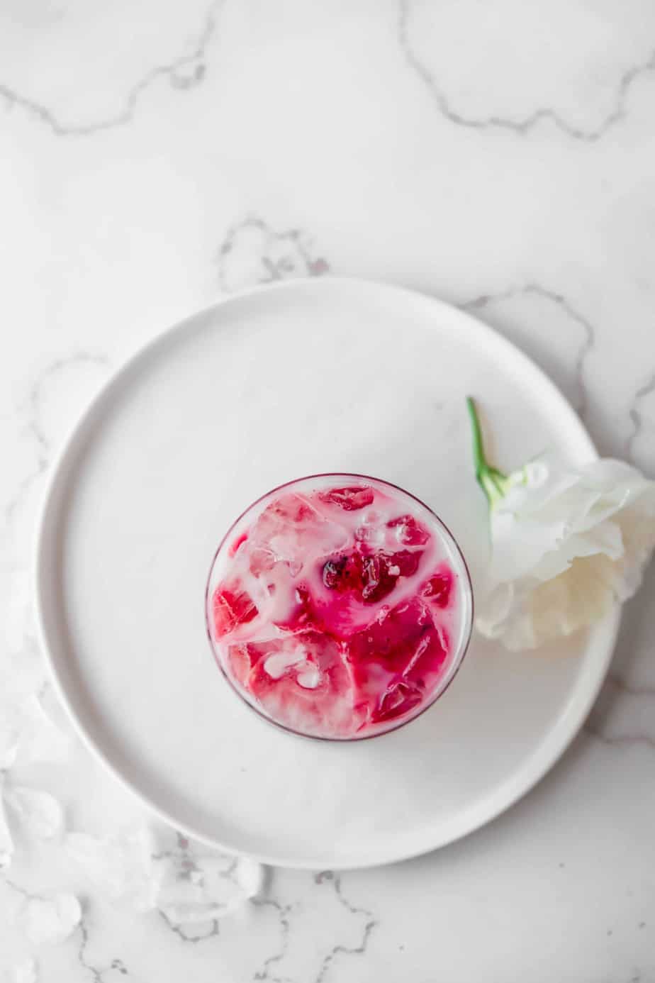 Homemade Iced Beetroot Latte with Coconut Milk in a glass on a plate.