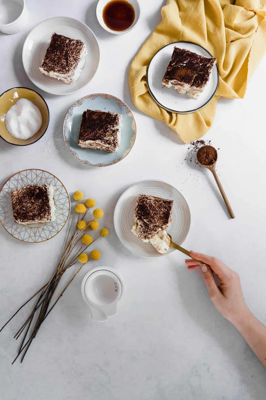 plates of healthy tiramisu with flowers and cocoa powder.