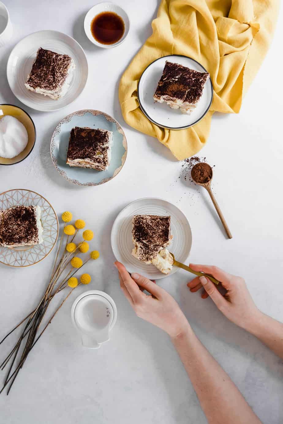 plates of healthy tiramisu with flowers and cocoa powder.