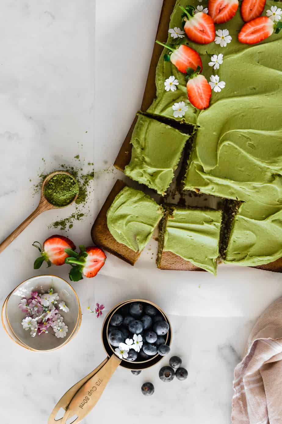Easy Matcha Sheet Cake with berries and flowers.