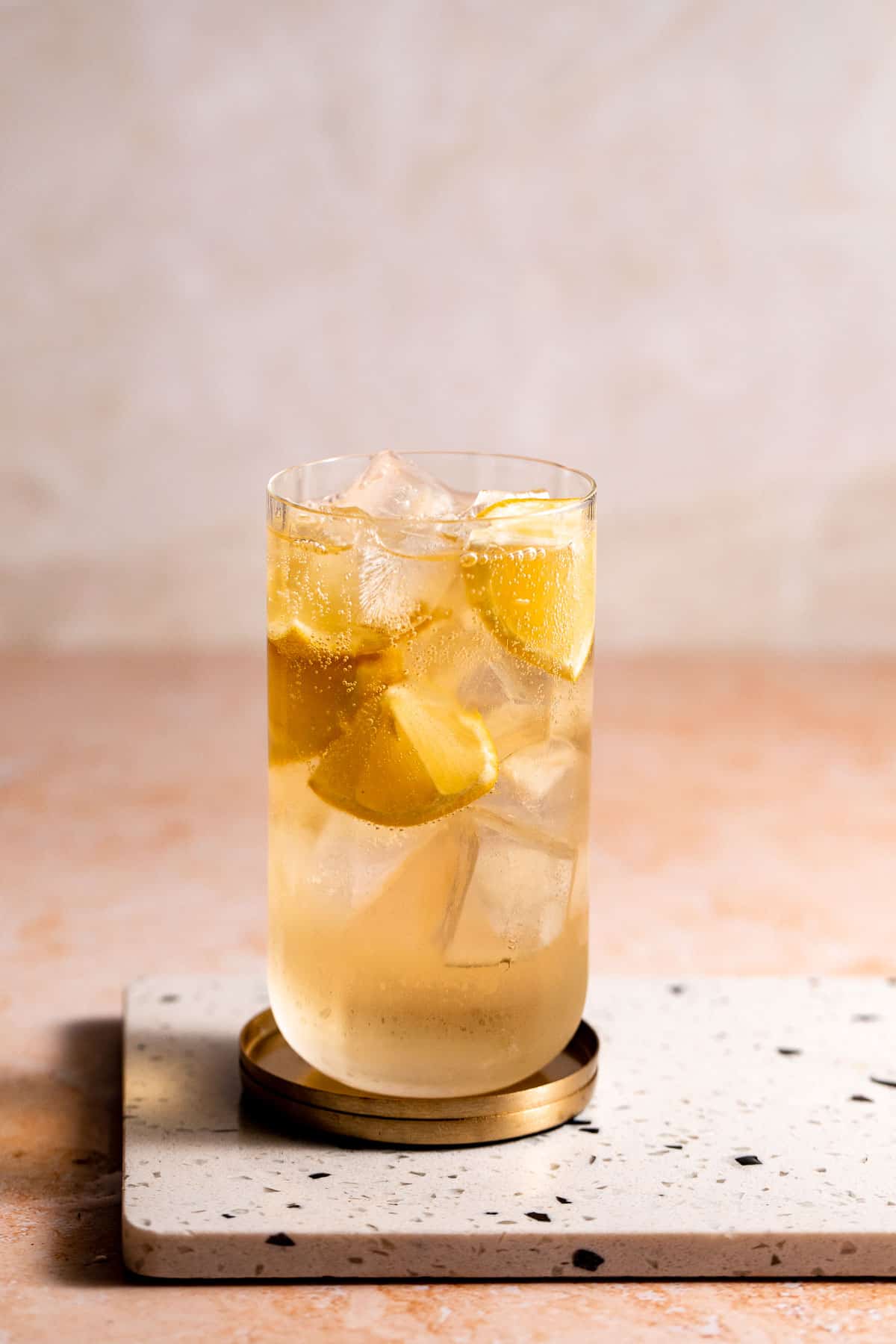 A 7 and 7 cocktail served with ice and lemon wedges in a highball glass.