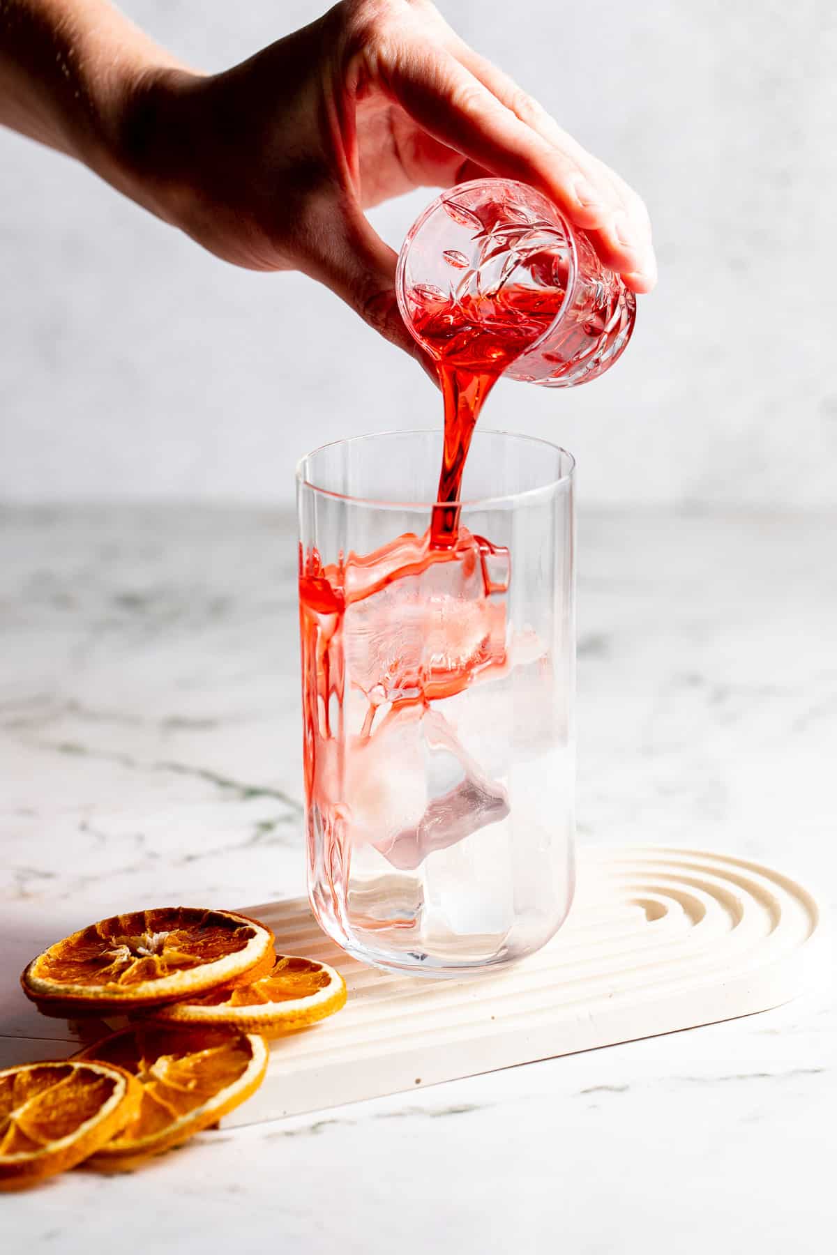 adding campari to glass over ice