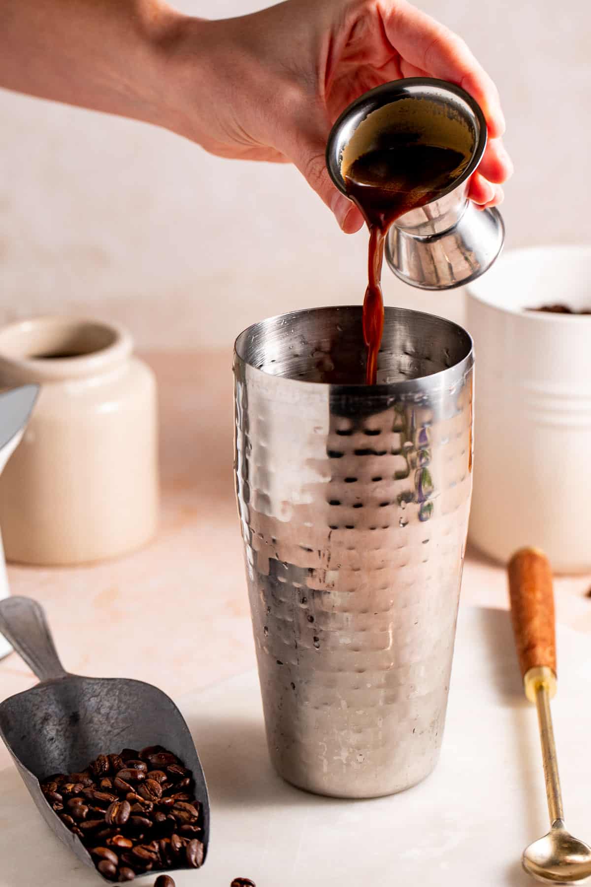 Espresso pouring into a cocktail shaker