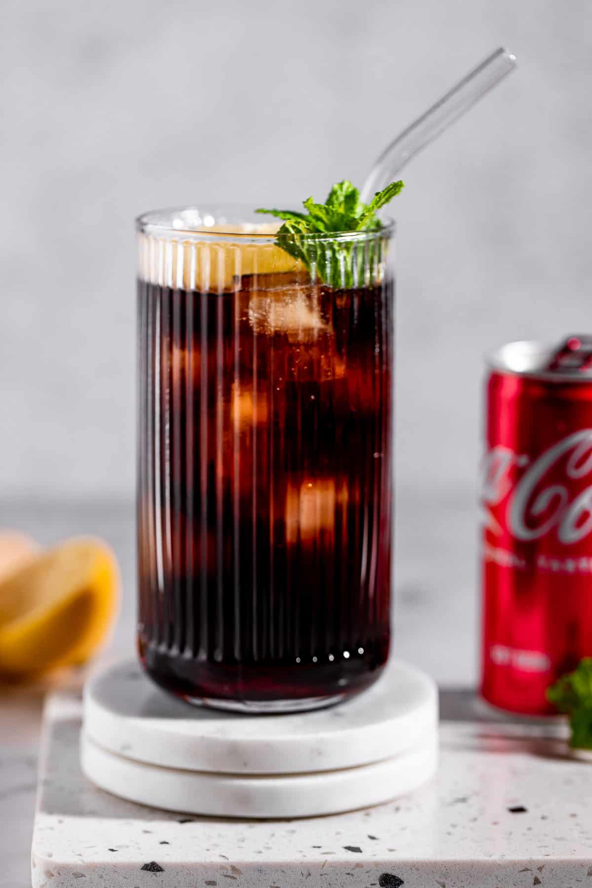 glass with coca cola and grenadine on marble coasters