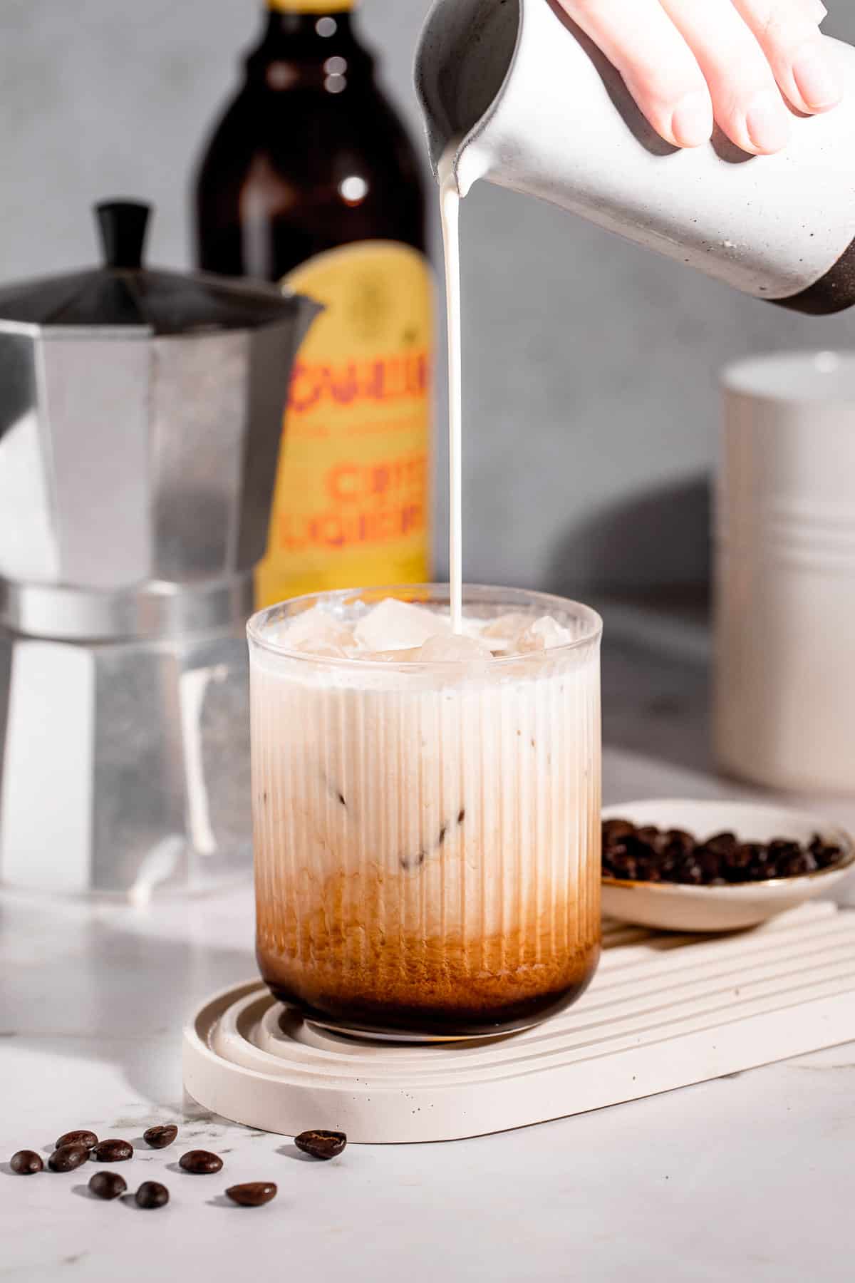 Cream pouring into a White Russian Screwball Drink.