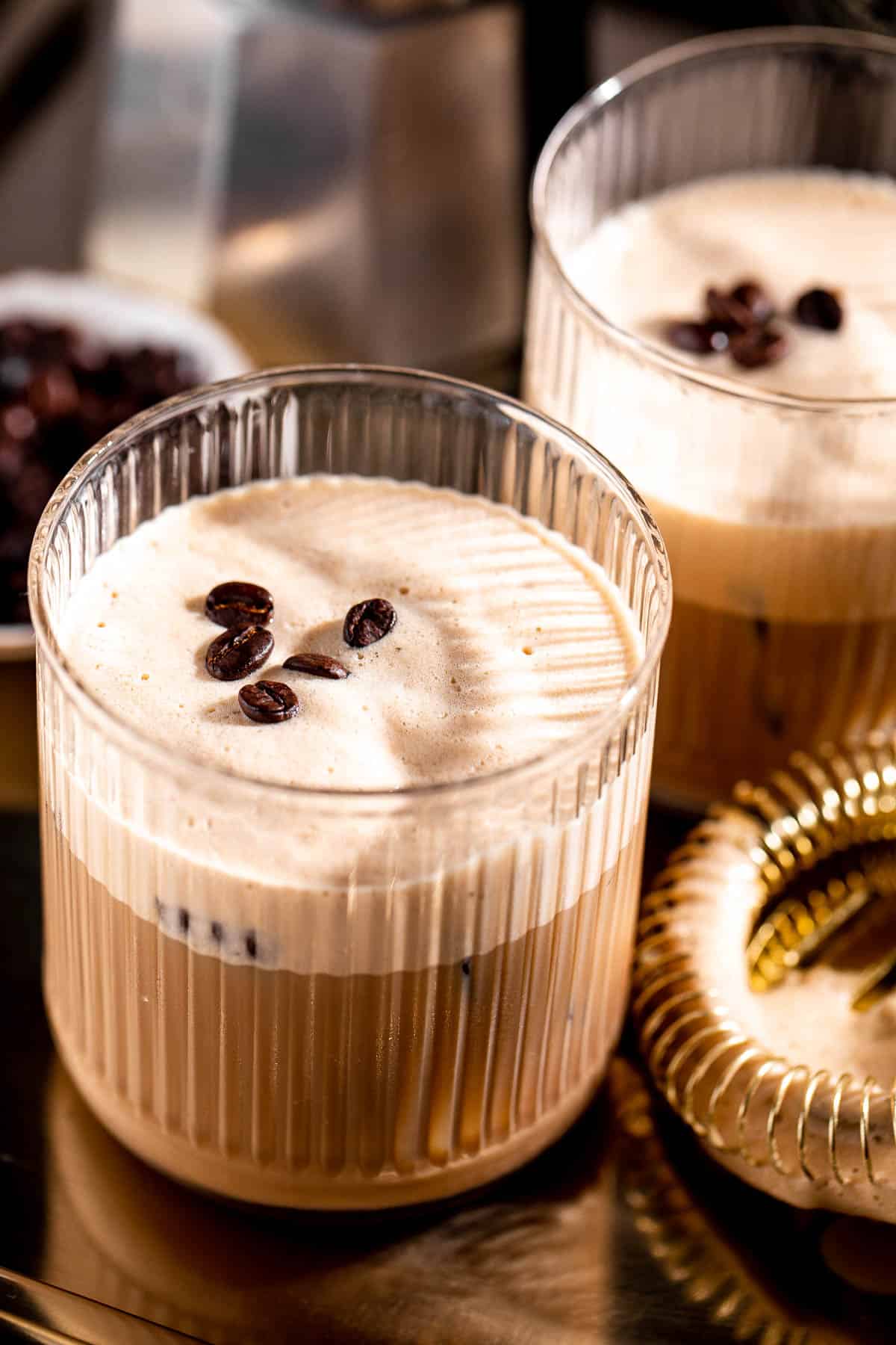 ribbed glasses on gold tray filled with shaft drink and topped with coffee beans